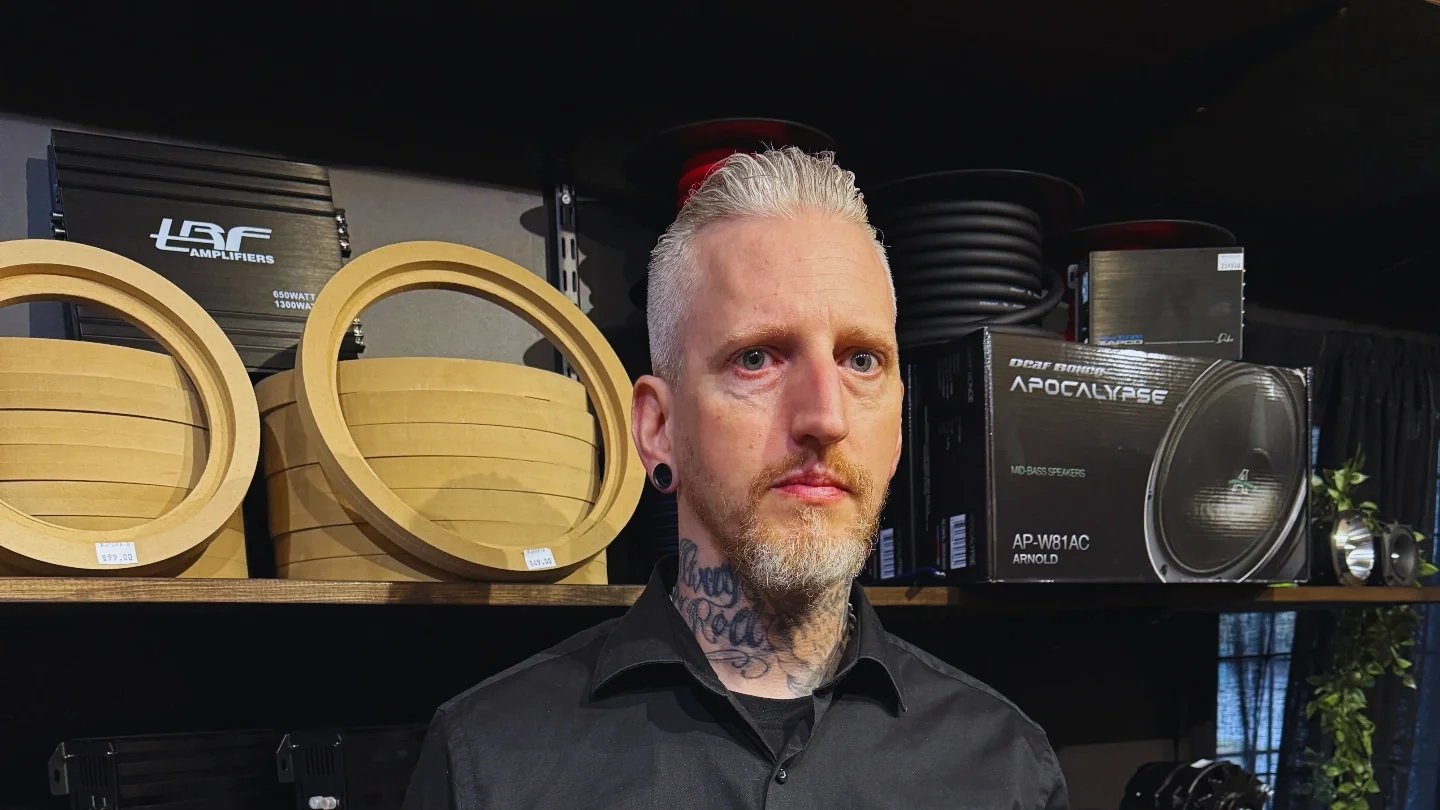Tony Fridlund, grundare av Friddes Stuff and Parts, framför hyllor med bildelar och luftfjädring